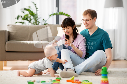 Image of happy family with baby boy at home