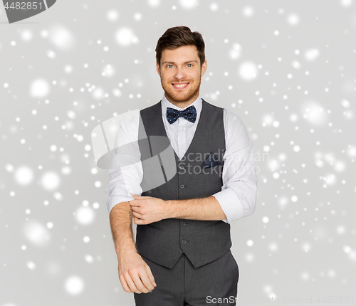 Image of happy man in festive suit dressing for party
