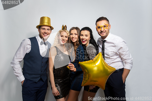 Image of happy friends with golden party props posing