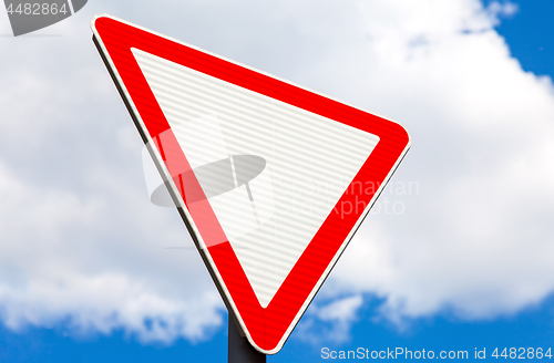 Image of Give way traffic sign above cloudy sky