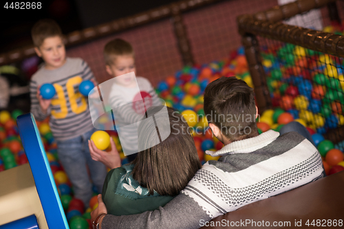 Image of young parents with kids in a children\'s playroom