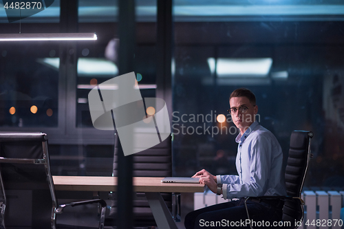 Image of man working on laptop in dark office