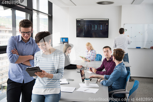 Image of Two Business People Working With Tablet in office