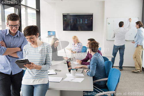 Image of Two Business People Working With Tablet in office