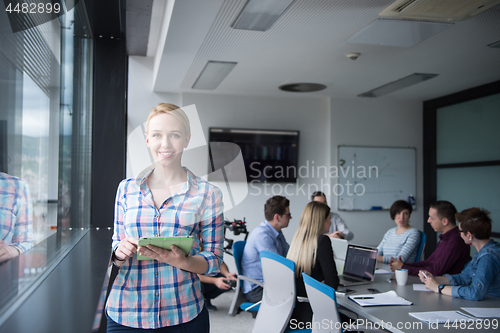 Image of Pretty Businesswoman Using Tablet In Office Building by window