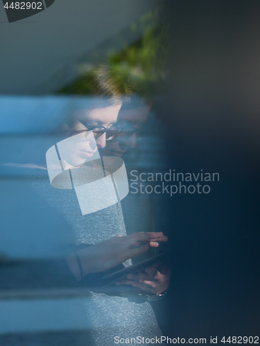 Image of Woman using tablet at home by the window