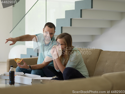 Image of couple eating pizza in their luxury home villa