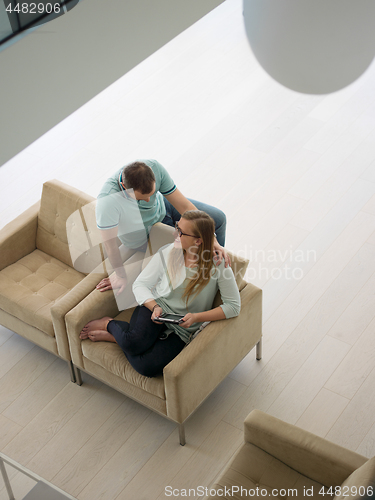 Image of couple relaxing at  home with tablet computers