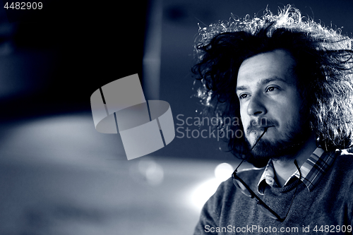 Image of man working on computer in dark office