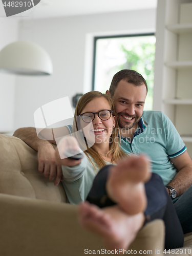 Image of Young couple on the sofa watching television
