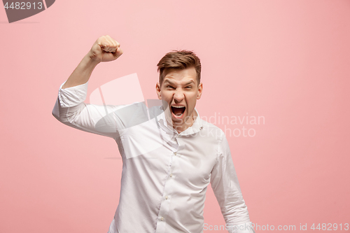 Image of The young emotional angry man screaming on pink studio background