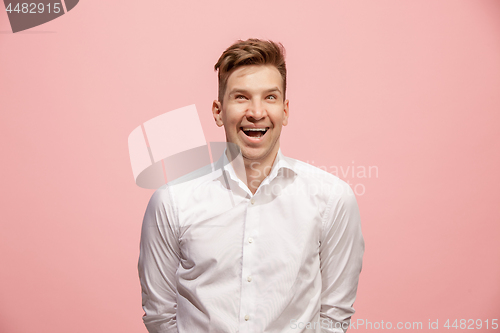 Image of The happy business man standing and smiling against pink background.