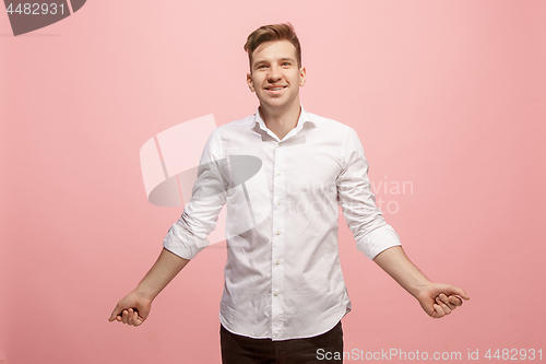 Image of The happy business man standing and smiling against pink background.