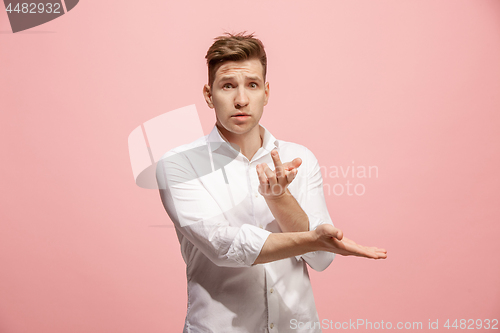 Image of Beautiful male half-length portrait isolated on pink studio backgroud. The young emotional surprised man