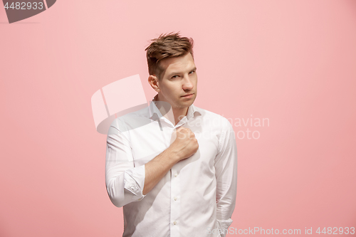 Image of Beautiful male half-length portrait isolated on pink studio backgroud. The young emotional surprised man