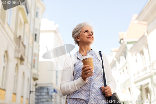 Image of senior woman drinking coffee at summer city