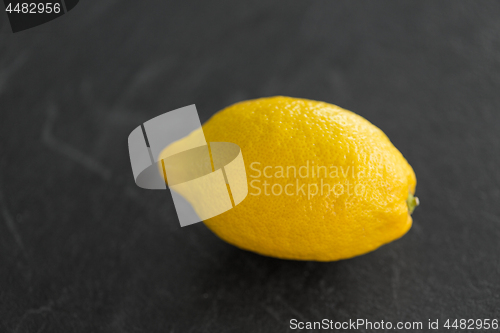 Image of close up of whole lemon on slate table top