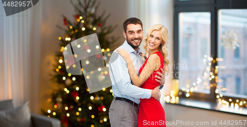 Image of happy couple hugging at home on christmas