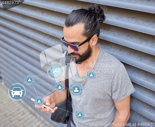 Image of man using smartphone car sharing app on street