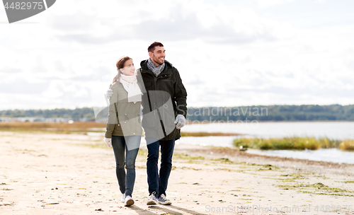 Image of couple walking along autumn beach