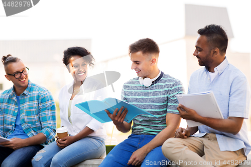 Image of international students with notebooks outdoors