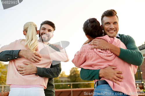 Image of couples or friends hugging at on rooftop party