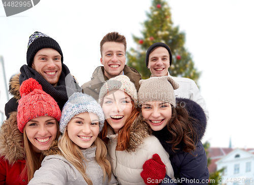 Image of happy friends over christmas tree in old tallinn