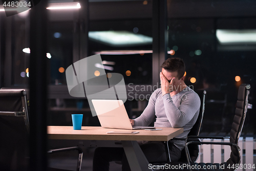 Image of man working on laptop in dark office