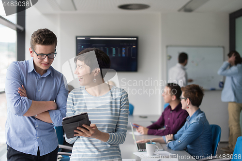 Image of Two Business People Working With Tablet in office