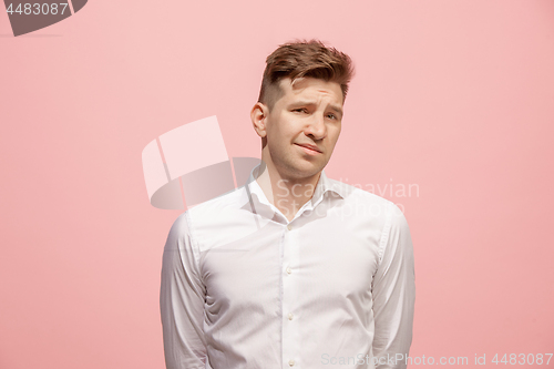 Image of Let me think. Doubtful pensive man with thoughtful expression making choice against pink background