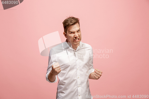 Image of The young emotional angry man screaming on pink studio background