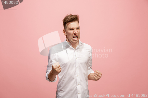 Image of The young emotional angry man screaming on pink studio background