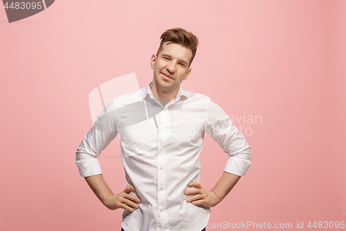 Image of The happy business man standing and smiling against pink background.