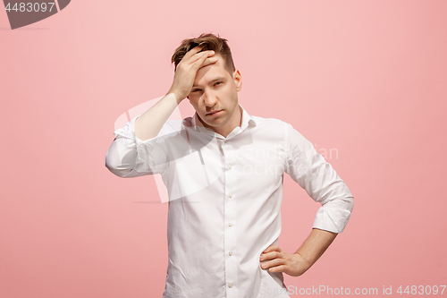 Image of Man having headache. Isolated over pink background.