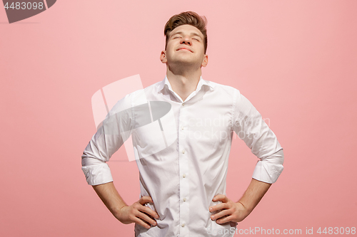 Image of The happy business man standing and smiling against pink background.