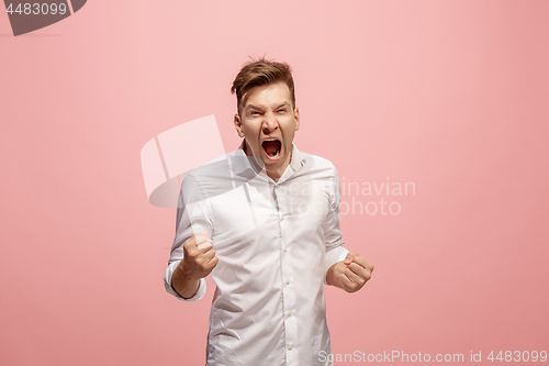 Image of The young emotional angry man screaming on pink studio background