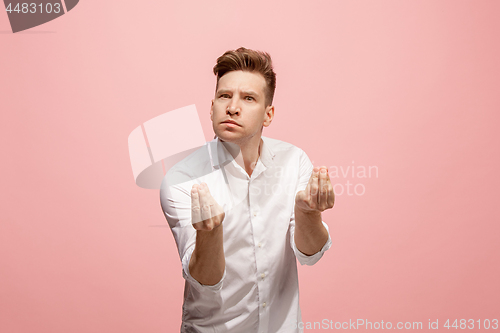Image of Beautiful male half-length portrait isolated on pink studio backgroud. The young emotional surprised man