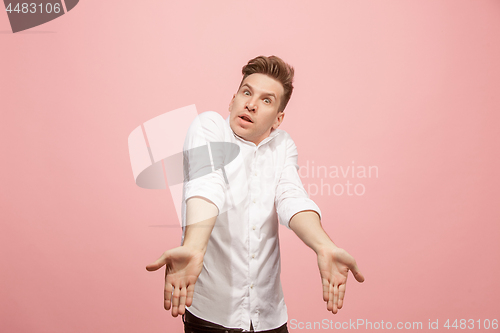 Image of Beautiful male half-length portrait isolated on pink studio backgroud. The young emotional surprised man