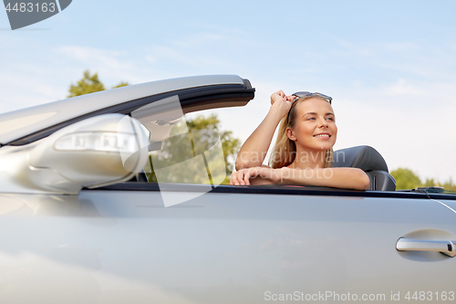 Image of happy young woman in convertible car