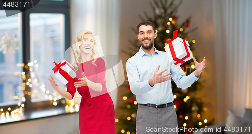 Image of happy couple with christmas gifts at home