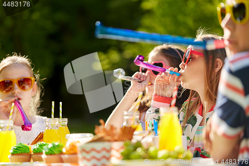 Image of kids blowing party horns on birthday in summer