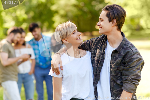 Image of happy teenage couple hugging at summer park