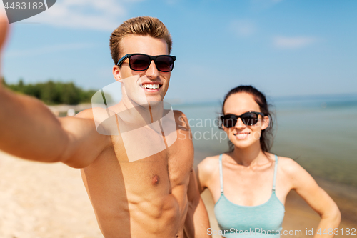 Image of couple taking selfie on summer beach