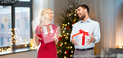 Image of happy couple with christmas gifts at home