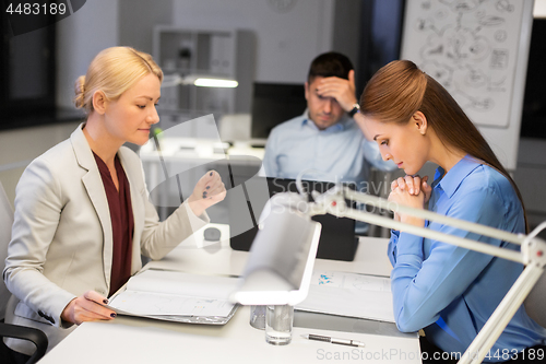 Image of business team with laptop working late at office