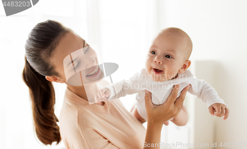 Image of happy mother playing with little baby boy at home