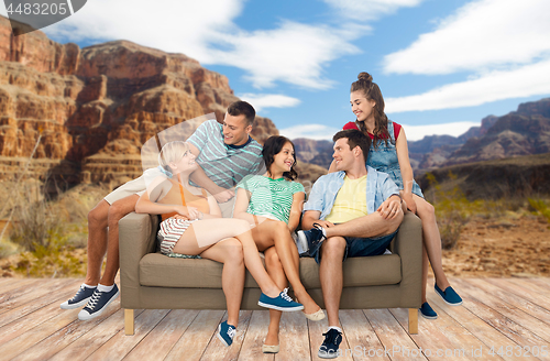 Image of friends sitting on sofa over grand canyon