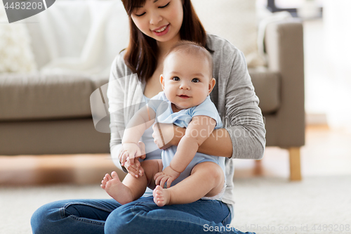 Image of happy young mother with little baby at home