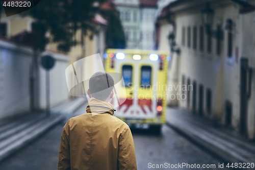 Image of Man looking at leaving ambulance car