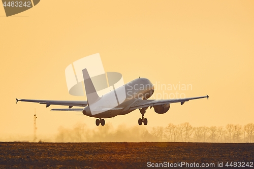 Image of Airplane taking off at sunset